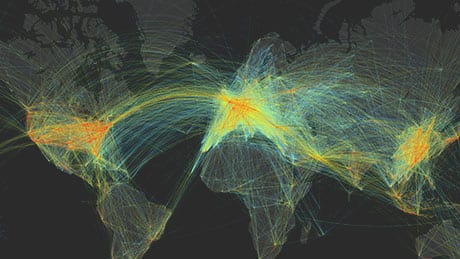 Colorful arcing lines showing air traffic flow on a world map