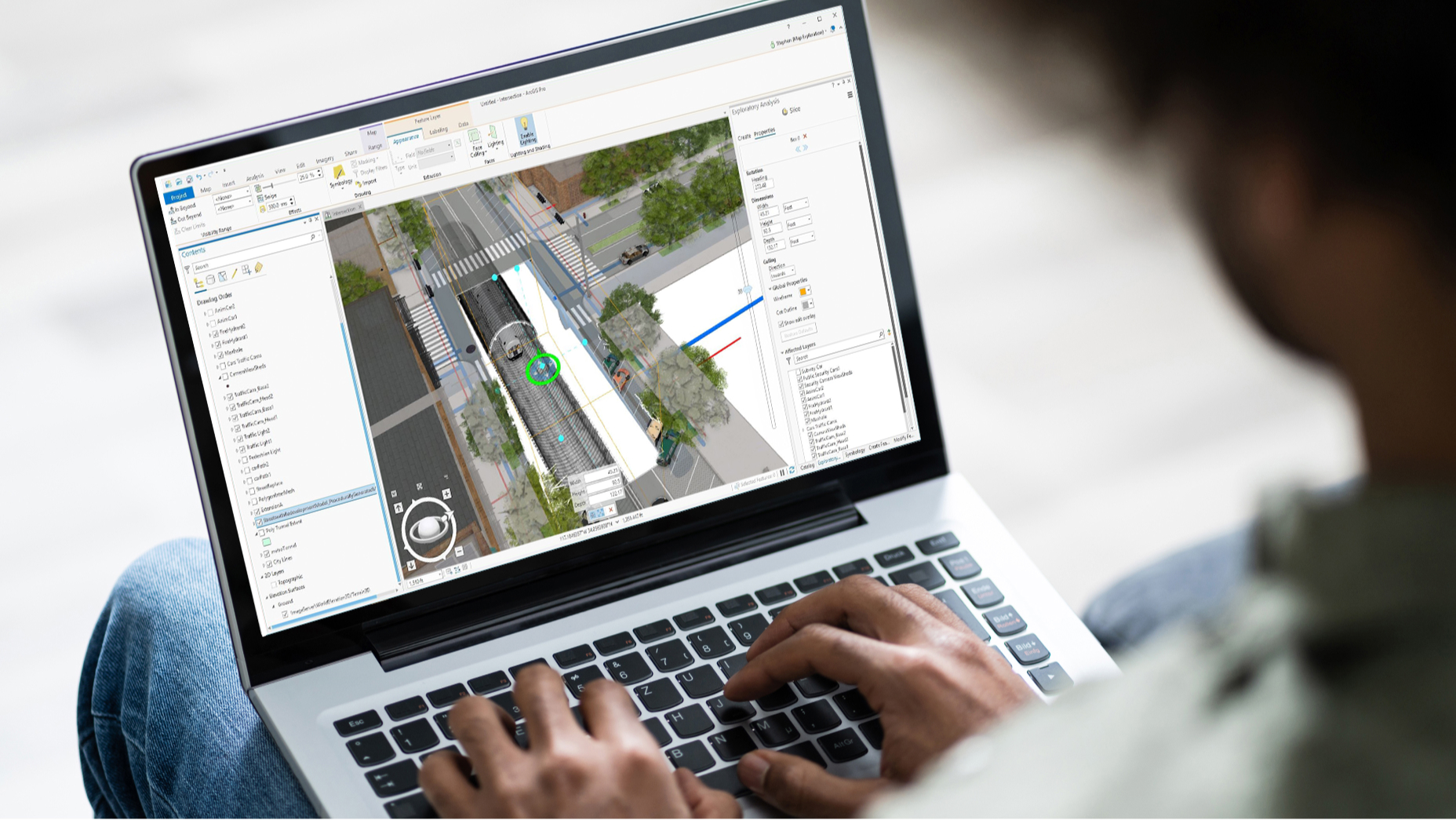 Pessoa em um laptop que exibe uma cena 3D de edifícios, vegetação e texto