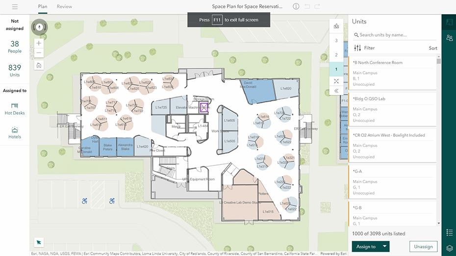 Um mapa interno 2D com escritórios destacados em quadrados azuis e cinzas no ArcGIS Indoors Spaces com uma caixa branca com texto 
