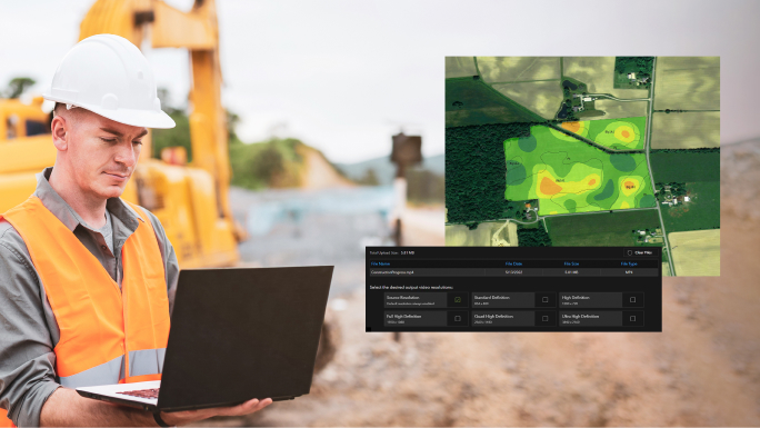 Um trabalhador da construção civil com um capacete branco olhando para um laptop com uma imagem digital inserida de um campo verde