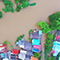 An aerial view of flooded trees and houses with brown, red, and blue roofs 