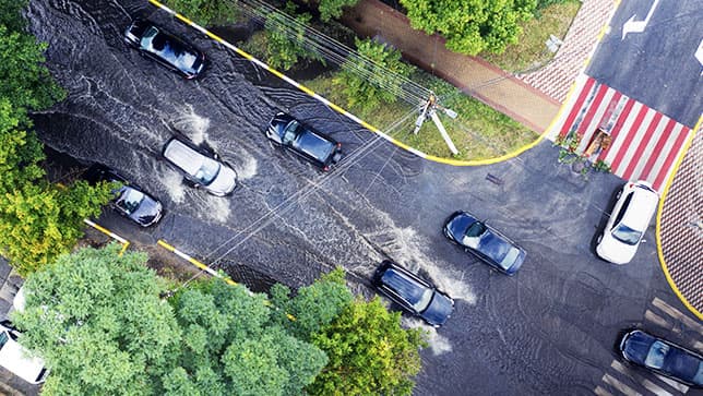 Vista aérea de carros dirigindo em uma estrada inundada