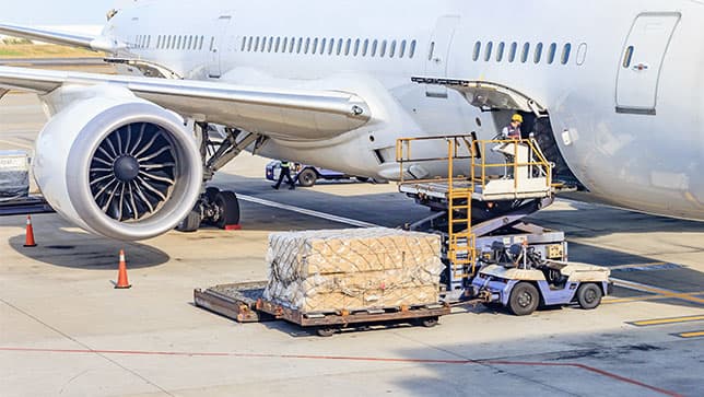 Um trabalhador descarregando uma grande carga de um avião